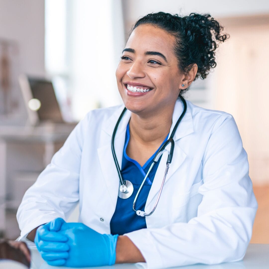 A physician smiles and listens to a patient