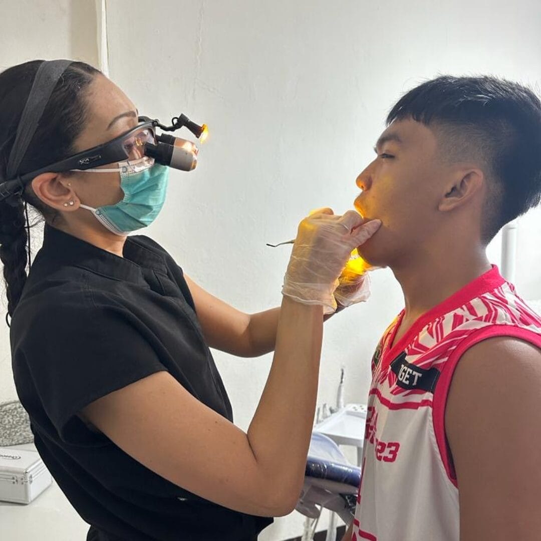 Dr. Christine Rizkalla performs dental services on a young boy