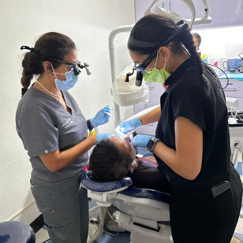 Dr. Christine Rizkalla and another dentist work on a patient