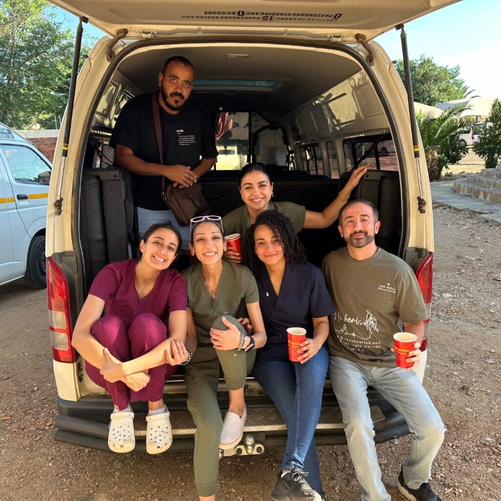 Dr. Christine Rizkalla with fellow volunteers sitting in the back of a van